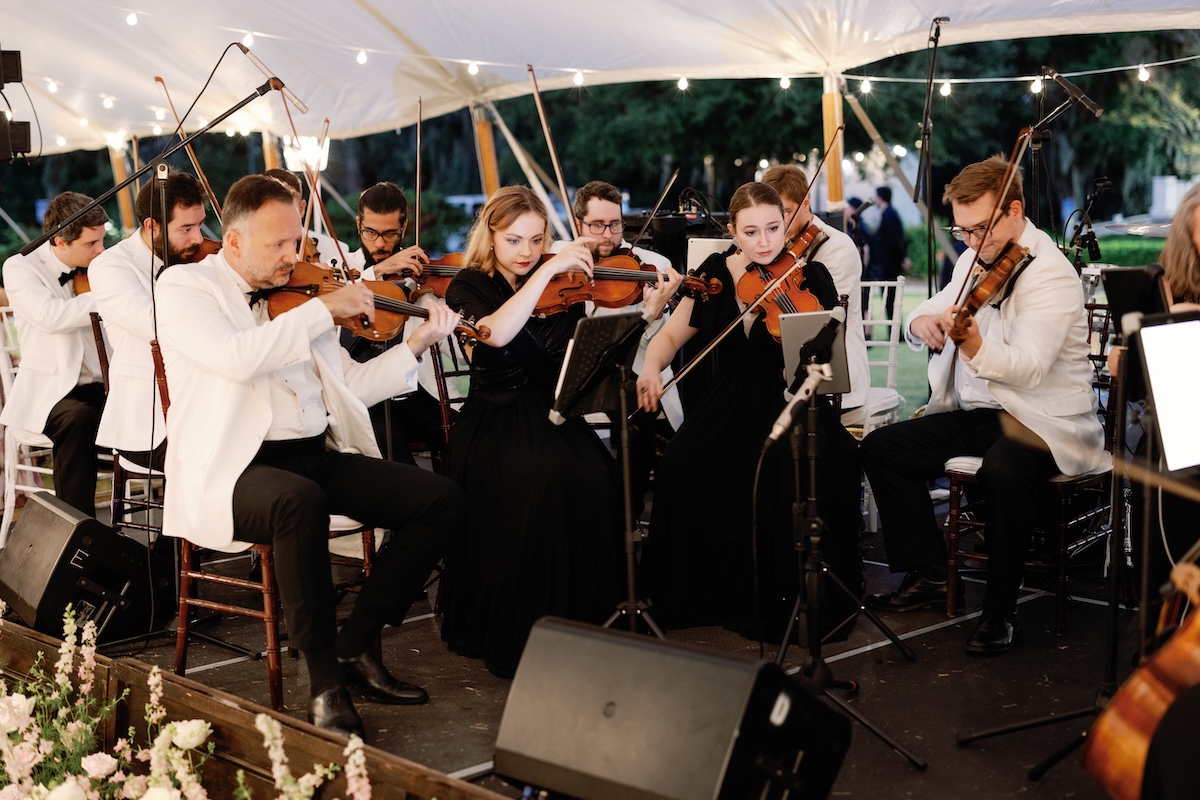 Pop string wedding orchestra with musicians; violinists wearing white tuxedos / white dinner jackets performin dinner set in Charleston, South Carolina